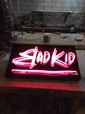 Wall Sign Wired pink neon lettering on black acrylic background